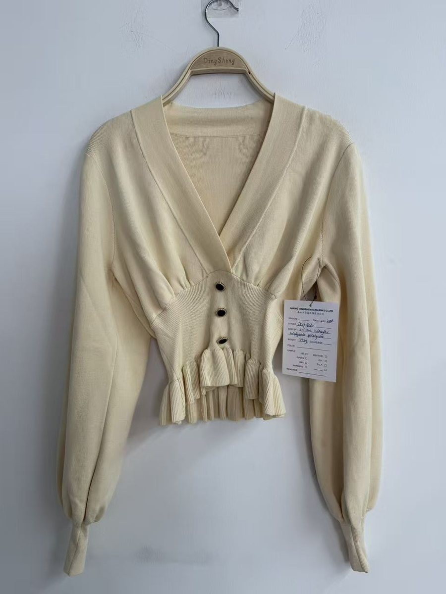 Cream wrap-front peplum pullover with puff sleeves, style DS27-K1010, from the Knitwear World sample collection