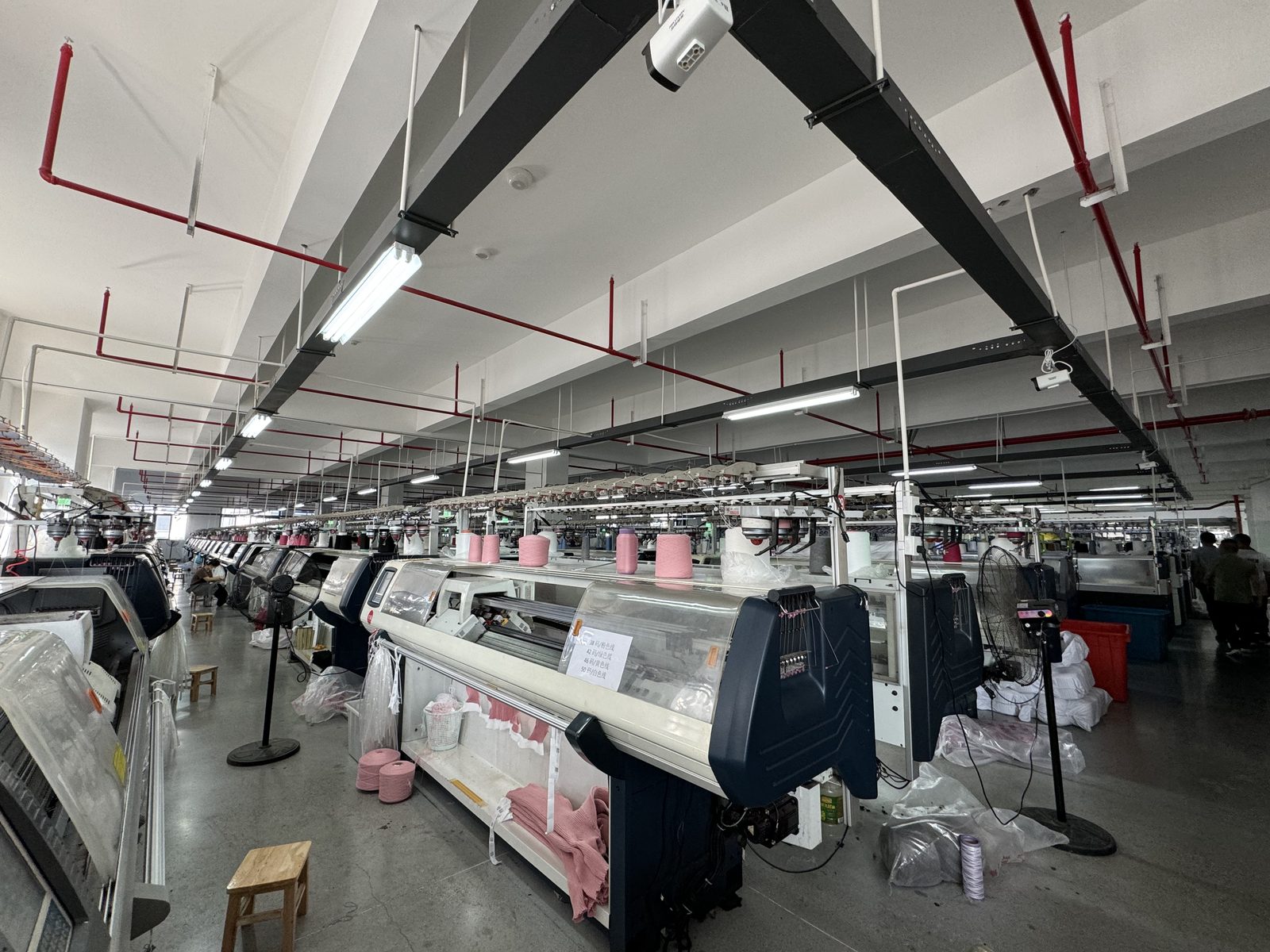 Computerized flat knitting machines on the knitting floor at Knitwear World, Jiaxing