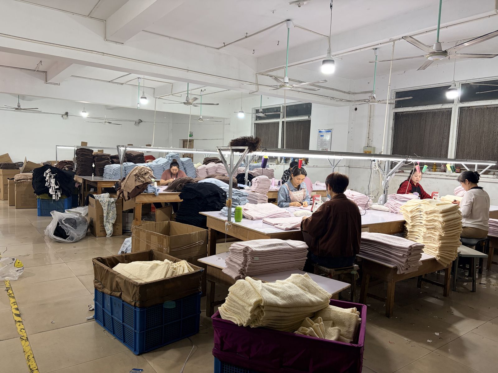 Final inspection and folding area at Knitwear World with finished sweaters ready for packing