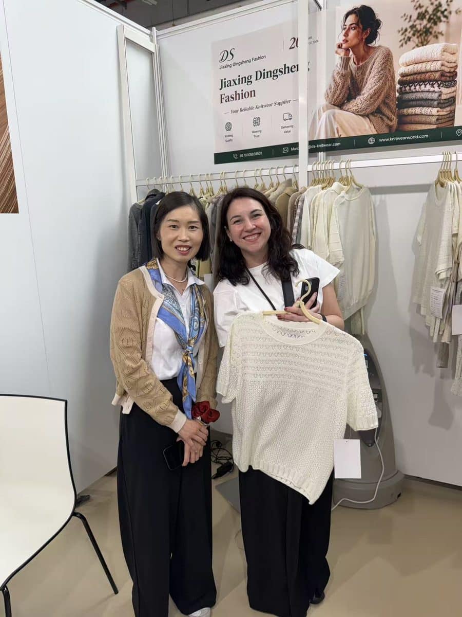 Marcia Lee and a buyer reviewing a pointelle knit top in Paris